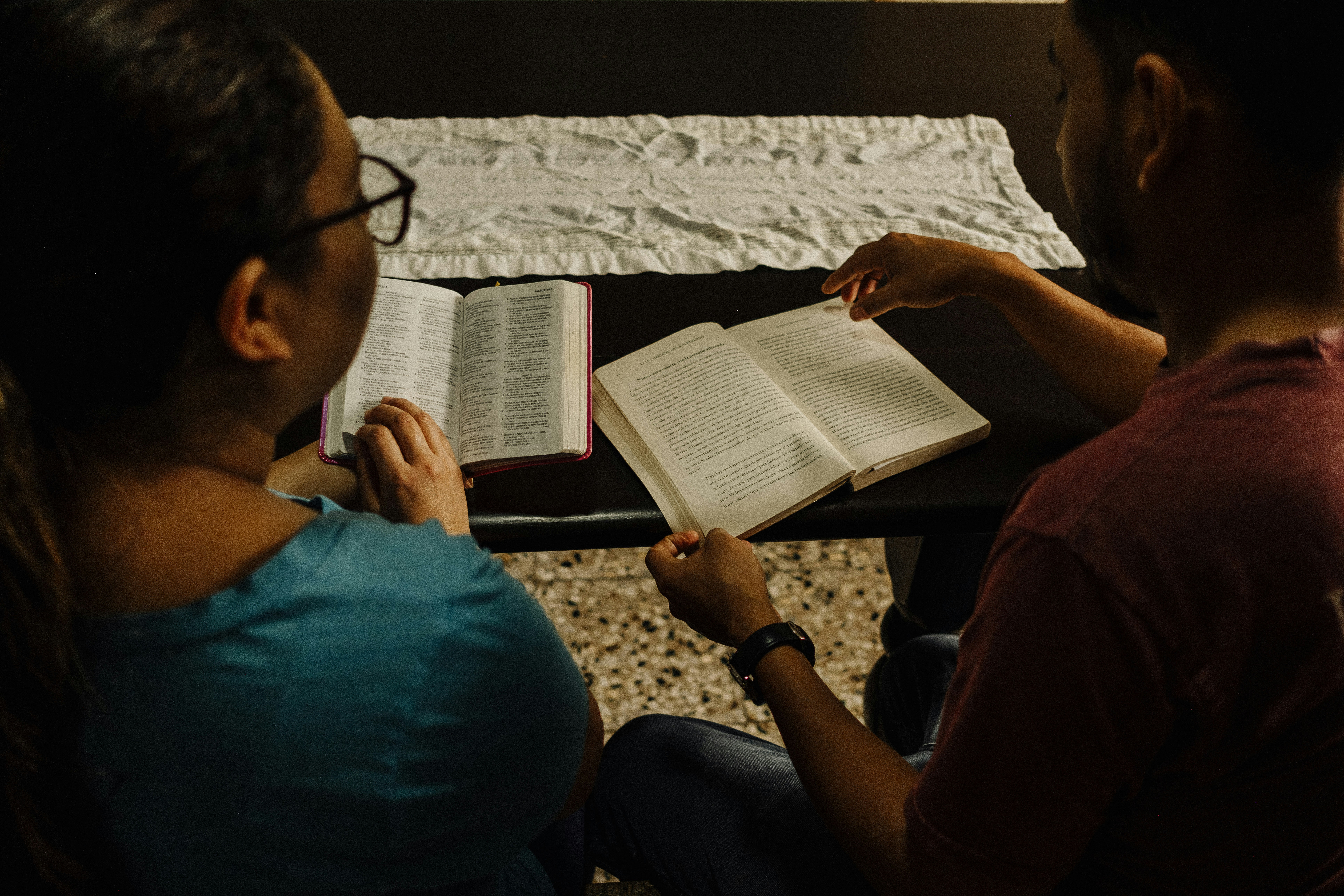 Two women praying together on a couch